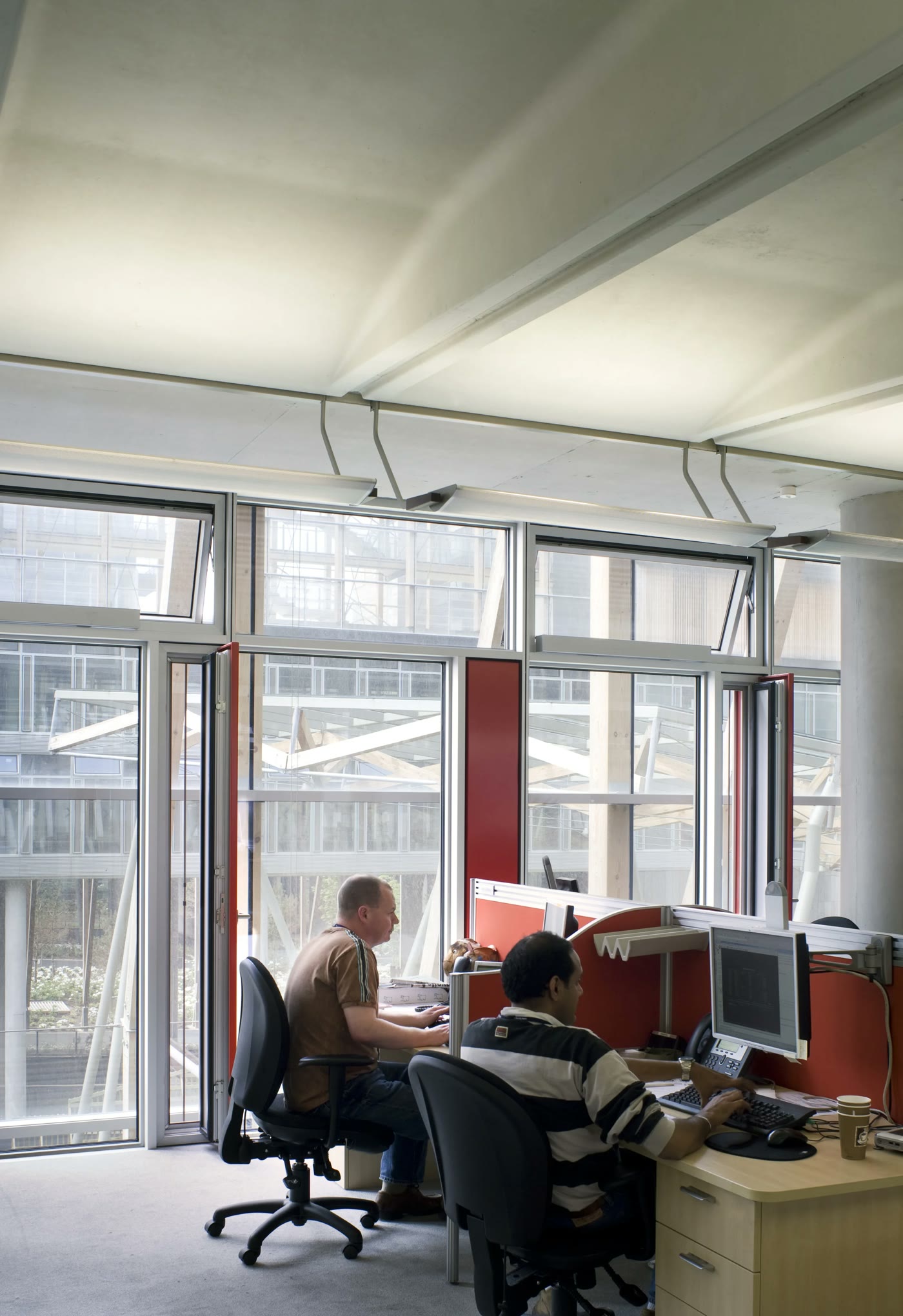 Two people working at desks by the open glass facade at Elmpark Green