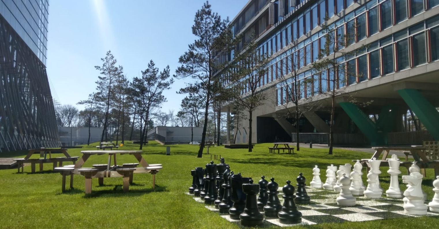Giant chess, picnic benches and the campus buildings on the lawn